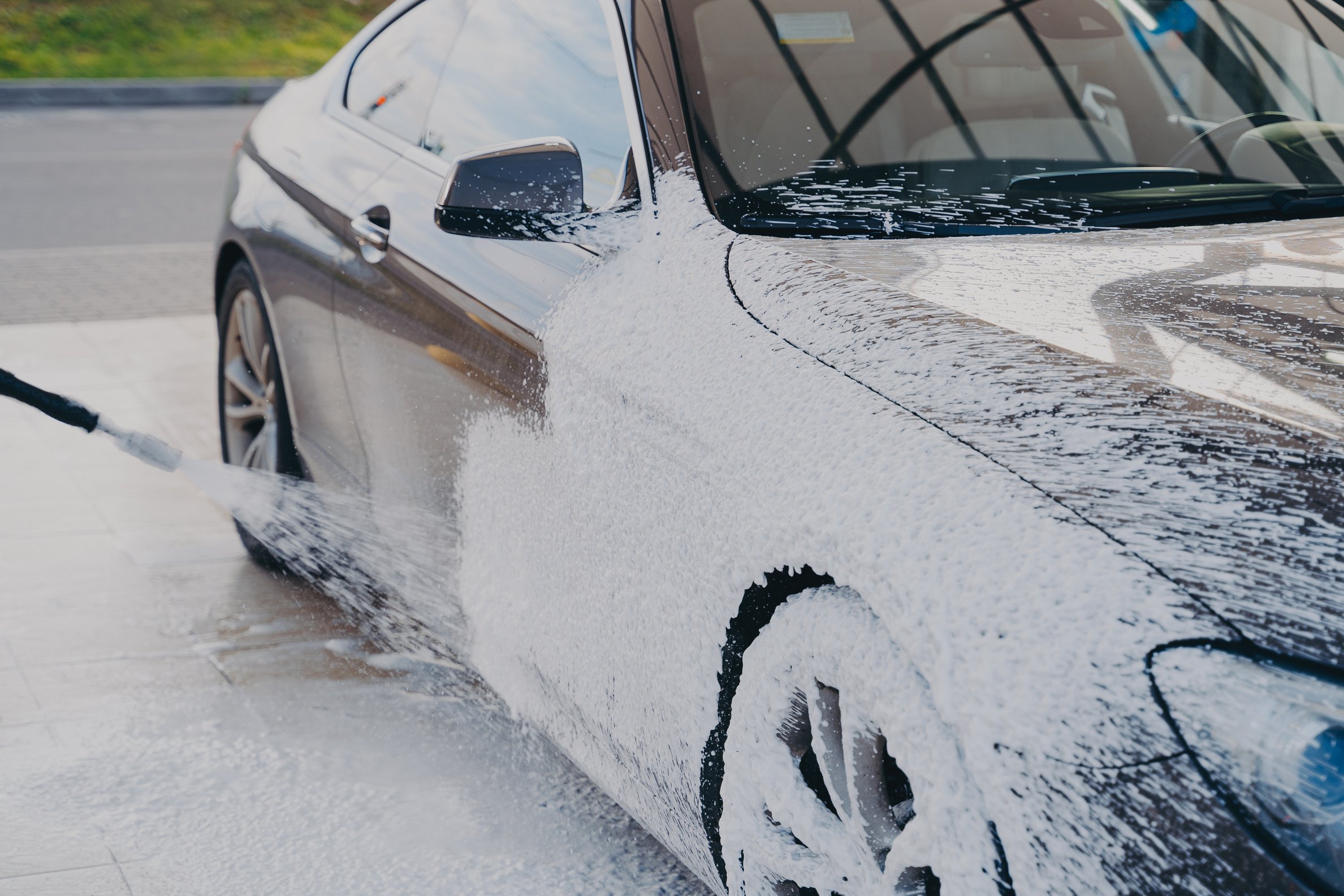 Black  Car in White Soap Foam at Car Wash Service Station